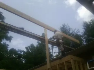 Carpenter setting a ridge beam over a new addition frame — Ice Dam Removal by Roofing Brothers in Cerrillos