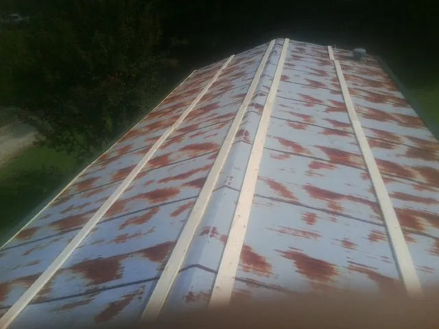 Rusted metal roof panels with new wood purlins before replacement — Storm Damage Roof Repair in Cerrillos by Roofing Brothers
