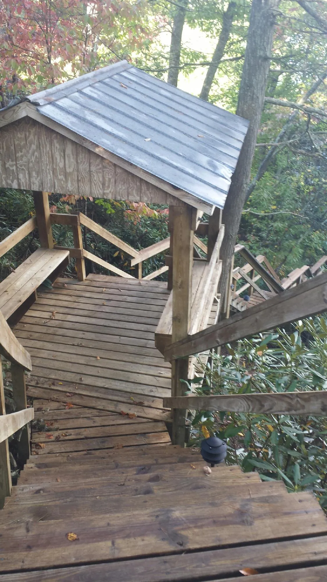 Metal roofed shelter over wooden steps on a wooded walkway — Skylight Repair & Installation work by our crew in Cerrillos
