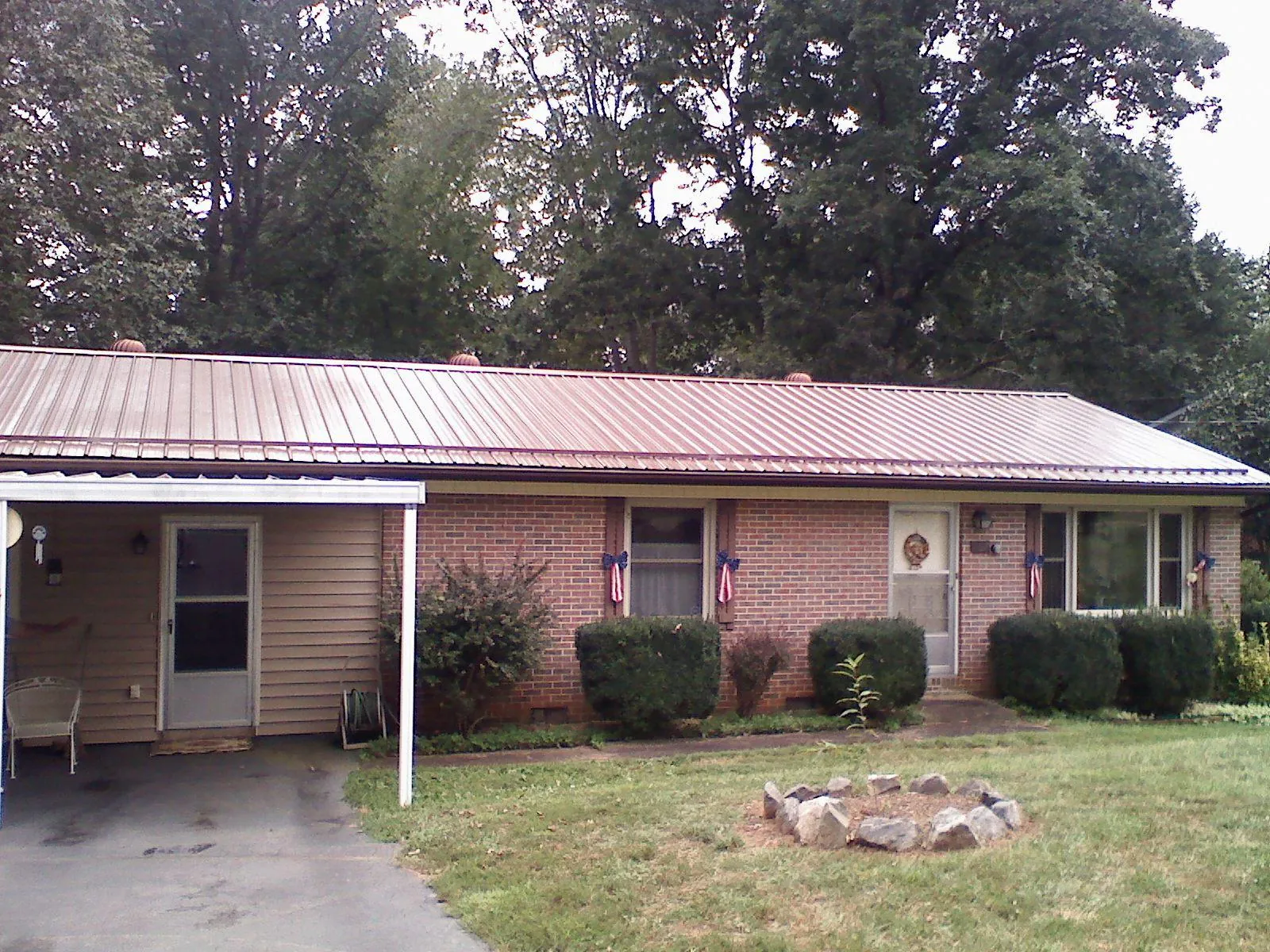 Bronze metal roof and carport on a brick ranch home — Roof Repair work by our crew in Cerrillos